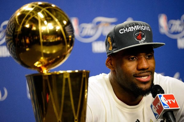 LeBron James ao lado do tão cobiçado trófeu de campeão da NBA